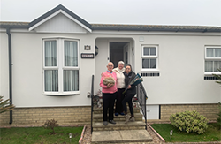 Photo of family standing outside a house