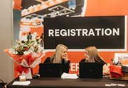 staff smiling sat behind visitor registration desk