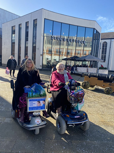 Two people using mobility scooters