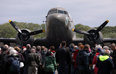 Image of a crowd of people standing in front of a plane
