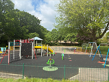 Longacres play area with trees in the background and blue sky