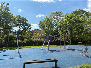 Sunlight gardens play area with trees in the background and blue sky