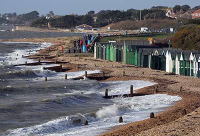 Hill Head beach with crashing waves and beach huts