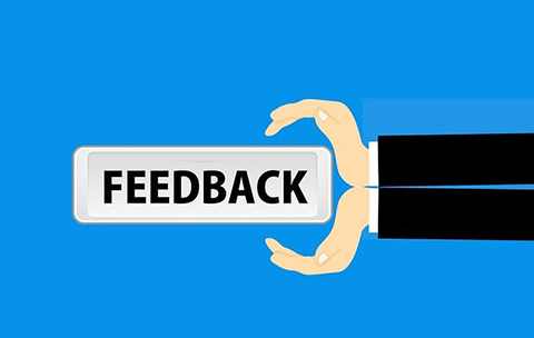 Cartoon hand holding sign saying feedback