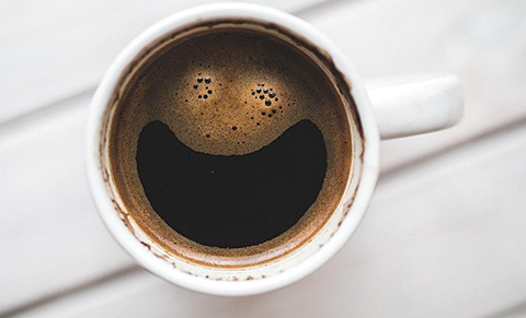 image of coffee with smiling face formed in the surface bubbles