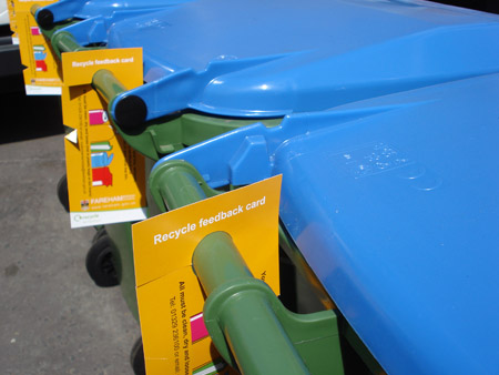 Yellow hangers on recycling bins