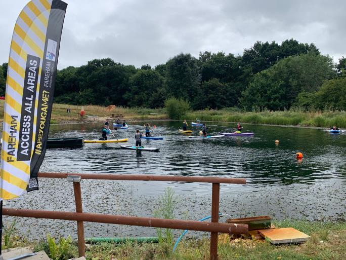 Photo of lake and children paddleboarding