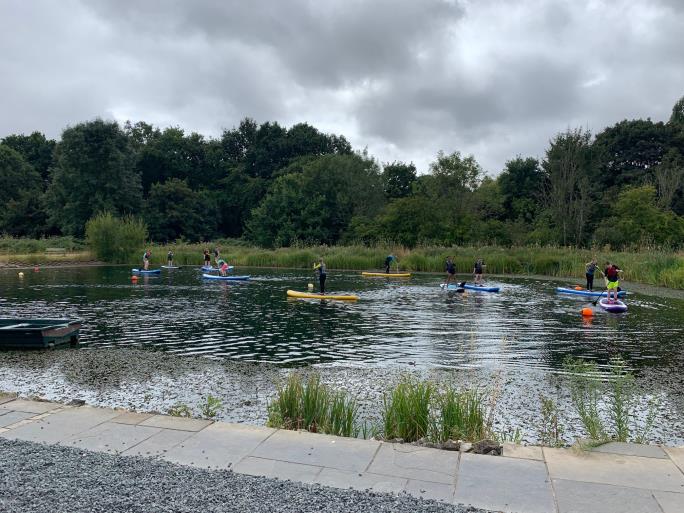 Photo of lake and children paddleboarding