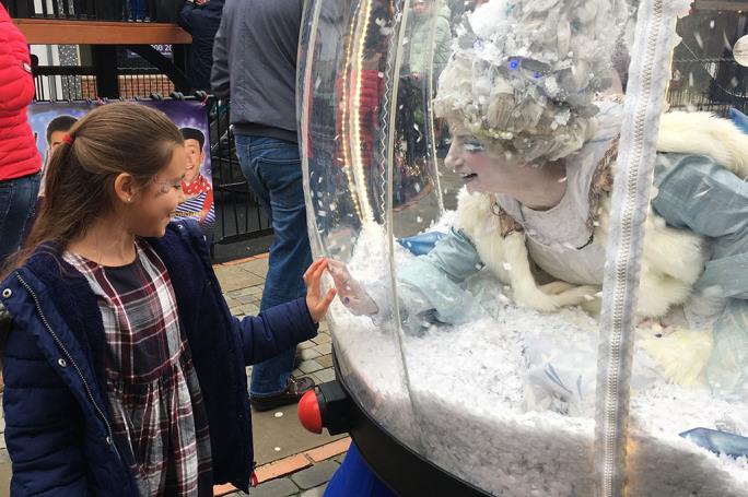 A child standing in front of giant snow globe
