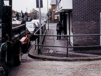 An image of Middle Road Park Gate shopping area showing shopfronts and railings with a damaged road surface in the foreground.